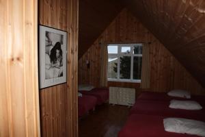 a attic room with two beds and a window at Ósar Hostel in Tjörn