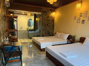 a hotel room with two beds and a bathroom at Flora Garden Homestay in Xuân Sơn