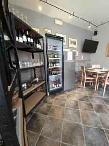 a room with a refrigerator filled with wine bottles at Hôtel La Métairie in Trois-Ponts