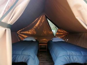 a tent with two beds in a room at Camping L'oasis Du Berry - chalets climatisés in Saint-Gaultier +72 photos