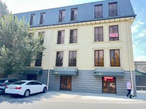 a white car parked in front of a building at Apartment lux in Samarkand