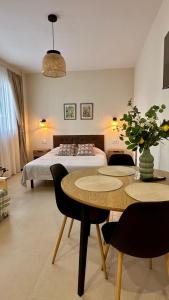 a bedroom with a bed and a table with chairs at Canoa Studio Vlc & Free filtered drinking water in Valencia