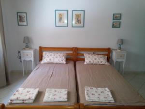 two twin beds in a room with two night stands at Smaragda Studios in Mikrós Prínos