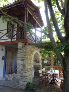 a house with a balcony and a table and chairs at House Rodia in Prinos