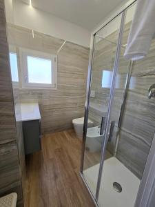 a bathroom with a shower and a toilet and a sink at Central Chic Apartment in Imola +5 photos