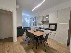 a kitchen and dining room with a table and chairs at Central Chic Apartment in Imola