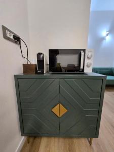 a green dresser with a microwave on top of it at Central Chic Apartment in Imola