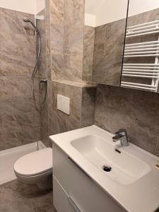 a bathroom with a white sink and a toilet at ApartmentRegina, renoviert! in Knittelfeld +18 photos