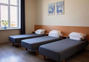 a room with two beds and a window at Stoties Hostelis in Vilnius