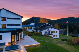 a house on a hill with a sunset in the background at Morgedal Hotel Spa & Resort - Unike Hoteller in Morgedal