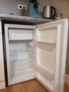 an empty refrigerator with its door open in a kitchen at Comfortable studio dans une maison au calme in Bellerive-sur-Allier