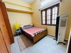 a small room with a bed and a window at Pavani staycation in Medchal