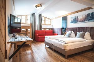 a hotel room with a bed and a couch and a tv at CORE Kaprun in Kaprun