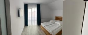 a bedroom with a bed and a window at Cezar House in Codlea