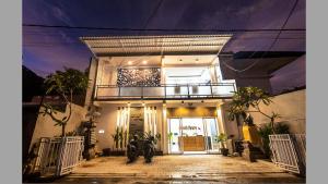 a house with two motorcycles parked in front of it at Cozy Guest House Canggu in Kerobokan
