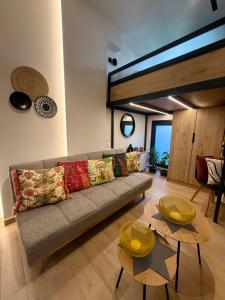 a living room with a couch and two tables at La Petite Mansion, next to the city center! in Volos