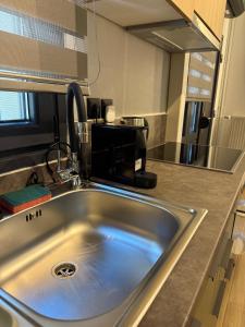 a kitchen counter with a sink and a microwave at La Petite Mansion, next to the city center! in Volos