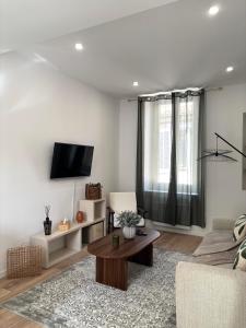 a living room with a couch and a table at Terrasse - CLIM - Arènes à pied - 4 pers in Nîmes +19 photos