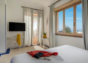 a bedroom with a bed and a tv and a window at Boutique Hotel Casa Mariantonia in Anacapri