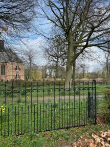 a black wrought iron fence in front of a cemetery at Slotje in Egmond aan den Hoef
