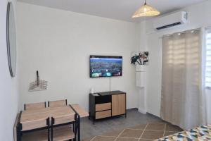 a living room with a table and a tv on a wall at Private Suite in Kourou