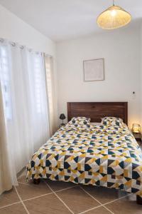a bedroom with a large bed with a checkered blanket at Private Suite in Kourou