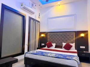 a bedroom with a large bed with red pillows at The Miraj Hotel in Murthal +9 photos