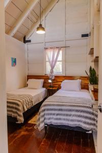 two beds in a room with a window at La Dama de los vientos in Cerro Azul