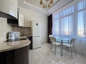 a kitchen with a table and chairs and a refrigerator at Delicious Aparts in Odesa