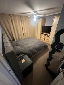 a small bedroom with a bed and a television at Newport by M4 in Newport