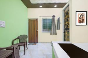 a room with a bed and chairs and a door at HOTEL O GUMTHI in Māharjhari +25 photos