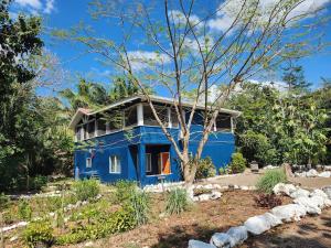 a blue house in the middle of a garden at The Gathering Place in Spanish Lookout