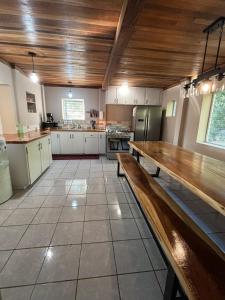 a large kitchen with a wooden table and a bench at The Gathering Place in Spanish Lookout