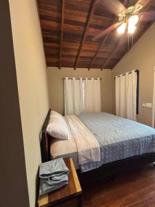 a bedroom with a bed and a wooden ceiling at The Gathering Place in Spanish Lookout
