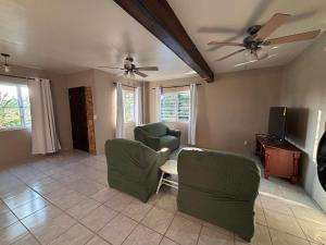 a living room with two chairs and a tv at The Gathering Place in Spanish Lookout