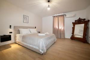 a bedroom with a large bed and a mirror at BellaDiAnna Apartment in Symi