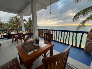 a porch with a table and chairs and the ocean at Ocean River View in Ambalangoda