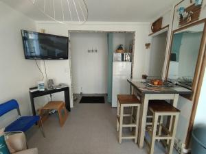 a room with a kitchen with a table and a refrigerator at Le Perret in Le Havre