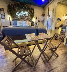 a table and two chairs in front of a bed at "Tree-T-Ment Center" Spa-Themed Luxury Treehouse with Indoor & Outdoor Soaking Tubs in Sevierville