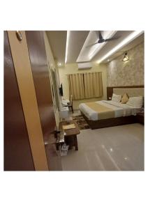 a hotel room with a bed and a desk at Hotel Zorba in Bhopal