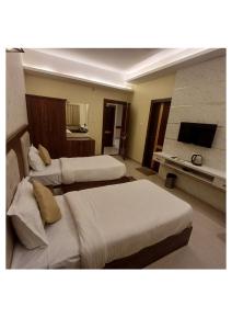 a hotel room with two beds and a fireplace at Hotel Zorba in Bhopal