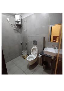 a bathroom with a toilet and a sink at Hotel Zorba in Bhopal