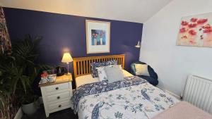 a bedroom with a bed and a blue wall at St Michael's Boutique Guest House, North Bay, Scarborough with free parking and fast wi-fi in Scarborough