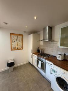 a kitchen with a stove and a washing machine at Superb 3-Bed Residence Airport in Dublin +30 photos