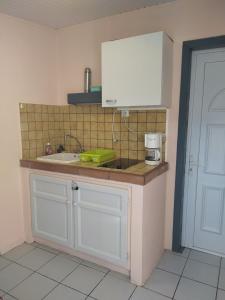 a kitchen with a sink and a counter top at Joli Studio à 5 min de la plage in Sainte-Anne
