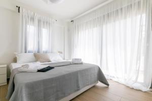 a white bedroom with a large bed with white curtains at Breeze Concept Villa in Drosia +50 photos