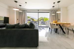 a living room with a couch and a dining table at Breeze Concept Villa in Drosia