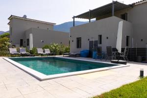 a swimming pool in front of a house at Breeze Concept Villa in Drosia