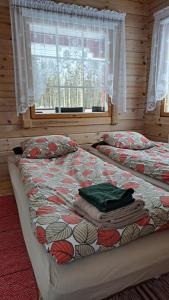 a bedroom with two beds and a window at Poromoision pirtti in Peurasuvanto