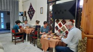 a group of people sitting at tables in a restaurant at Garden Palace Khiva in Khiva